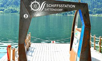 An access point to the shipping station in Sattendorf. In the background, the calm lake and the surrounding mountains are visible.