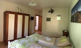 A cozy bedroom with a double bed and a large wardrobe. The walls are painted in soft colors, and there are decorations that create a relaxed atmosphere.