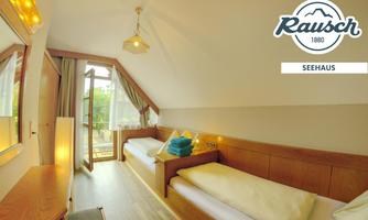 A cozy room with two single beds and a balcony. The large windows provide plenty of daylight and a beautiful view outside.