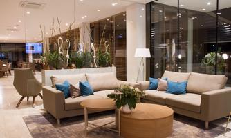 A modern living room with comfortable sofas and stylish decorations. Large windows let in plenty of light and create an inviting atmosphere.