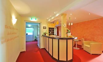 An inviting reception area with a reception desk and comfortable seating. The walls are painted in warm colors, creating a pleasant atmosphere.