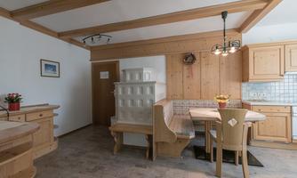 A cozy kitchen with wooden furniture and a dining area. The room is bright and inviting.