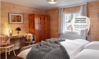 A cozy room with two beds, a wooden wardrobe, and a table. Soft colors and a warm atmosphere invite you to relax.
