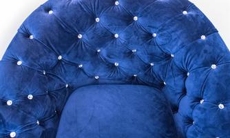 An elegant, round armchair in deep blue velvet with sparkling rhinestones. It offers a comfortable seating place and adds a luxurious touch to the room.