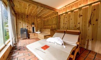 A cozy room with wooden walls and a large window. Relaxation and tranquility are the focus on the lounge.