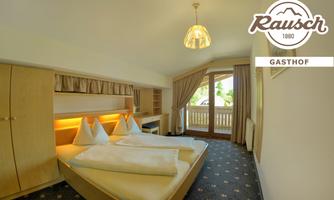 A simple and modern room with two beds and light wood. Large windows provide a view outside and ensure plenty of daylight.