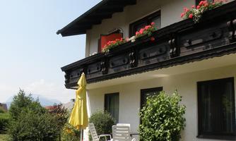 A cozy house with a balcony where colorful flowers bloom. The garden is well-maintained and invites you to relax.