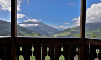 A picturesque mountain landscape with green meadows and tall mountains. The sky is clear and the view is beautiful.