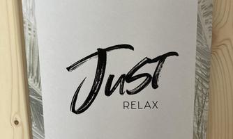A poster with the inscription "Just Relax" in stylish letters. It has a minimalist, elegant background with palm motifs.