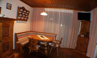 A cozy dining area with traditional wooden furniture and a pleasant atmosphere. The windows let in plenty of light and give the room an inviting feeling.