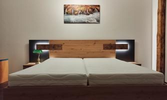 A modern bedroom with a large, bright bed and wooden details. A picture with a landscape motif hangs on the wall.