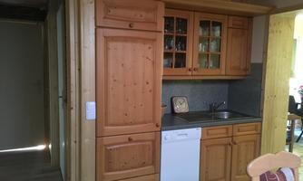 A cozy kitchen with wooden cabinets and modern amenities. The walls are light, creating a friendly atmosphere.