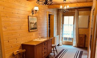 A cozy hallway with wood paneling and a wardrobe. The window offers a view outside and lets in plenty of light.