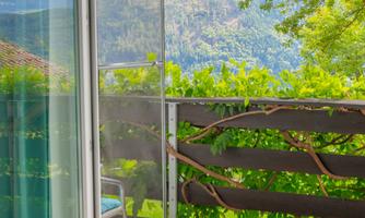 From the bed, you can already see the greenery and the mountains. The balcony door lets in plenty of light and fresh air, and the view of nature instantly brings a vacation feeling into the room. Here you start your day with peace instead of city noise.