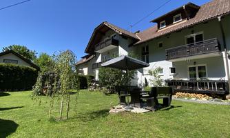 A beautiful house with a well-maintained garden. A terrace with seating and a sun umbrella invites you to relax.