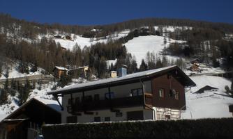A charming house in the mountains, surrounded by snowy slopes. The landscape is peaceful and picturesque, perfect for winter activities.