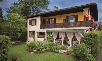 A nice house with two floors and a balcony. The garden is green and inviting, perfect for relaxing outdoors.