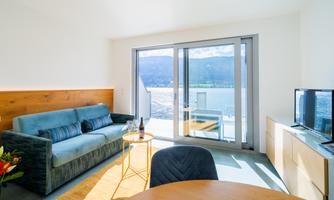 Bright and modern living room with a view of the water. A cozy sofa and a small table invite you to relax.