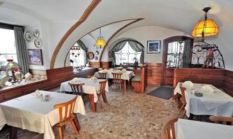 A cozy restaurant with round tables and wooden decor. The lighting is warm and inviting.
