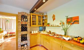 A modern kitchen with light wooden furniture and a built-in wine barrel. Fresh fruit and delicious snacks are on the countertop.