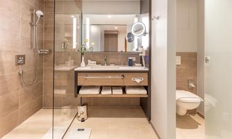 A modern bathroom with a glass shower and an elegant sink. The warm colors and stylish decor create a relaxed atmosphere.