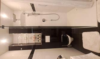A modern bathroom with a shower and elegant tiles. There are towels and a well-equipped WC area.