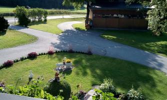 A beautiful garden with lawn areas and colorful flower beds. In the background, a building and trees can be seen.
