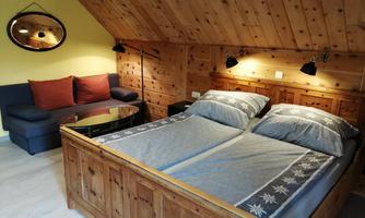 Junior suite with a double bed, wood paneling and a seating area.