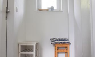 Friendly hallway with a window, small seating area, and shoe rack – ideal for neatly storing jackets, shoes, and bags, and for arriving relaxed.