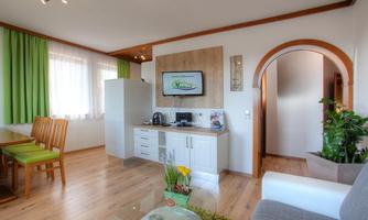 A bright and inviting apartment with modern design. The kitchen is well-equipped and there is a cozy dining area.