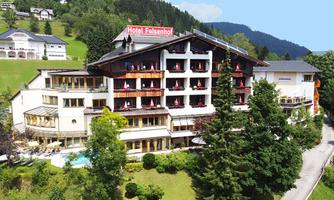 A beautiful hotel surrounded by trees and mountains. The outdoor area features a pool and an inviting terrace.