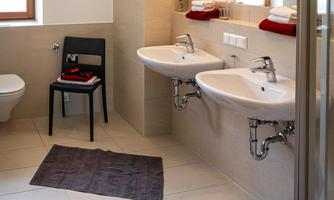 A modern bathroom with two sinks and large mirrors. The neutral color tones and decorative towels create a cozy atmosphere.