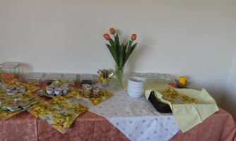 A set table with colorful tulips in a vase and various snacks in decorative containers. The tablecloth is in warm colors and creates an inviting atmosphere.