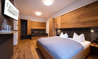 A modern room with wooden paneling and a cozy bed. The warm colors create an inviting atmosphere.
