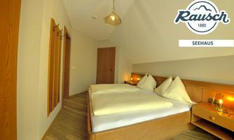 A modern bedroom with a double bed and warm wooden details. The walls are light, and the lighting creates an inviting atmosphere.