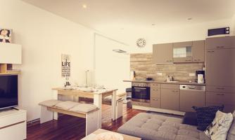 A modern kitchen with an open living area. The room is bright and friendly with a dining table, a couch, and modern kitchen appliances.