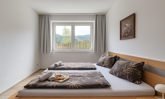A modern bedroom with two single beds and elegant bedding. The room has large windows that overlook a green landscape.