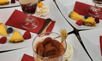 Delicious dessert in glasses on white plates. Accompanied by fresh fruits and decorative red napkins.