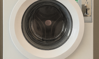 A modern washing machine with a round door. Label: "For our guests."