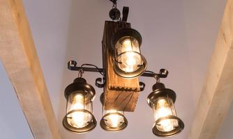 A stylish ceiling lamp with four light bulbs hangs from the ceiling. The design combines wood and metal, creating a warm light.