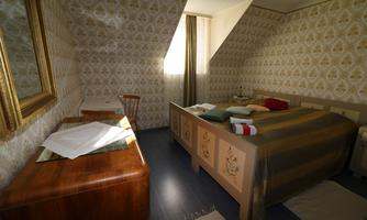 A cozy bedroom with a double bed and a wooden table. The walls are decorated with a nostalgic pattern.