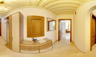 A modern hallway with bright walls and wooden details. On the left side, there are cabinets and a table that make the space inviting.