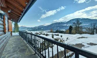 A beautiful view from a porch of snow-covered mountains and a clear sky. The serene landscape offers a peaceful atmosphere.