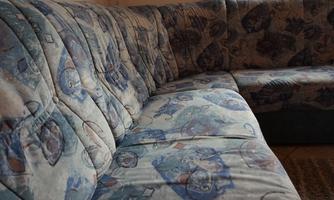 A cozy corner sofa with a colorful, patterned cover. The room has plenty of light and an inviting atmosphere.