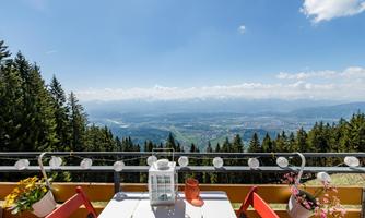 A beautiful view of the mountains and the valley. Flowers and a lantern are on the table.