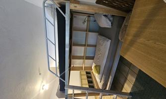 A modern room with a bunk bed and a table. The decor is simple and functional, ideal for a cozy stay.