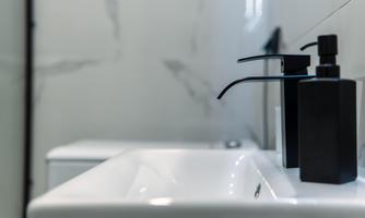 Modern bathroom view with an elegant sink and stylish soap dispensers. The clear lines and minimalist design create a calm atmosphere.