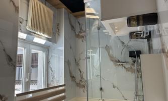 A modern bathroom with a glass shower and an elegantly designed sink line. Large windows allow for plenty of daylight and a bright atmosphere.
