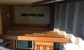 An entrance with a modern door and wood cladding. Advantageously positioned steps lead to the entrance.