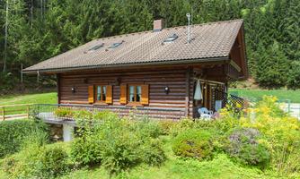 A rustic wooden house with a beautiful garden. Surrounded by trees and a picturesque landscape.